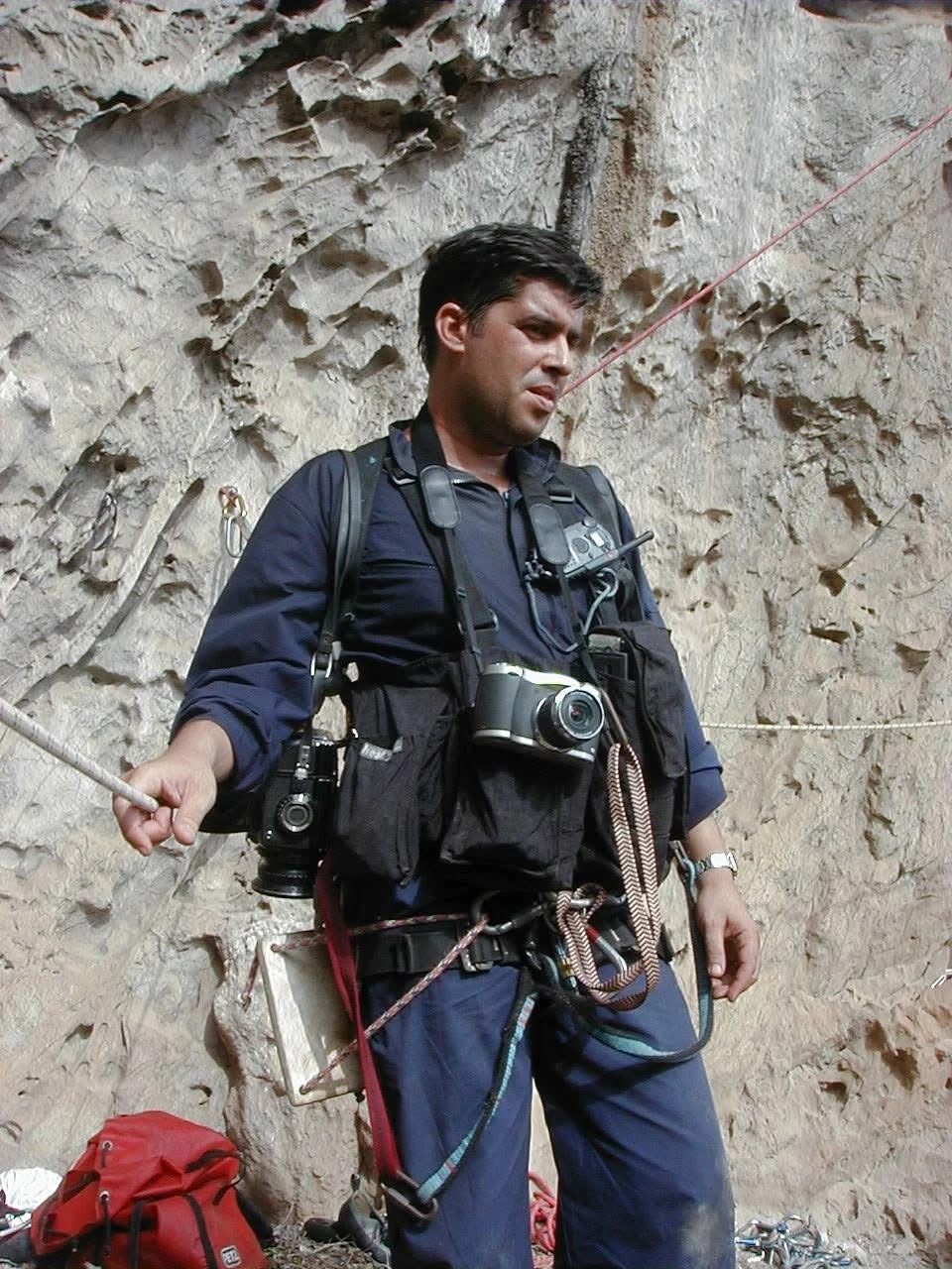Ahmed Velázquez en pared de roca, con sus cámaras y el arnés