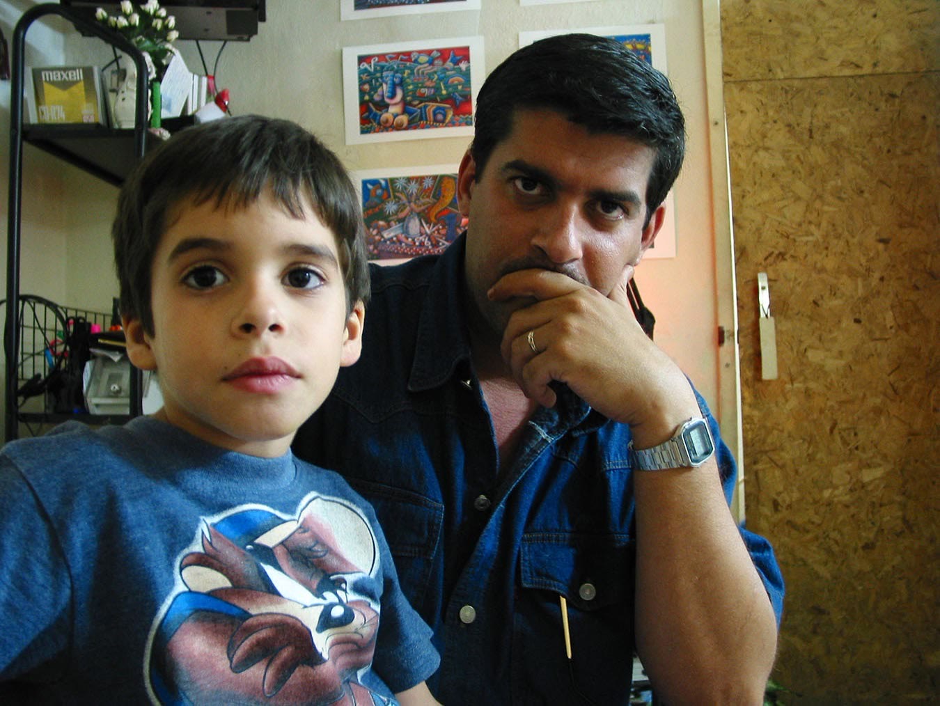 Hazeem Velázquez de niño junto a su padre, Ahmed Velázquez, los dos mirando a la cámara en el taller