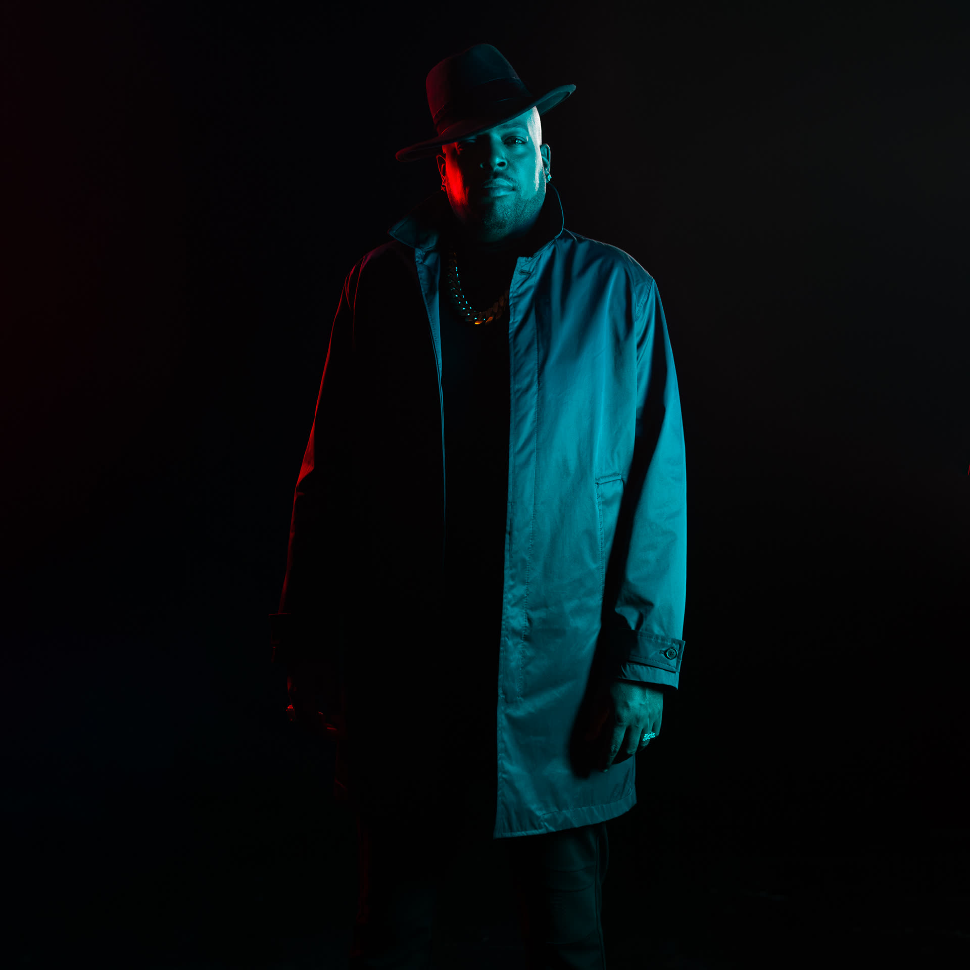 Retrato de un hombre con abrigo bajo luz roja y azul