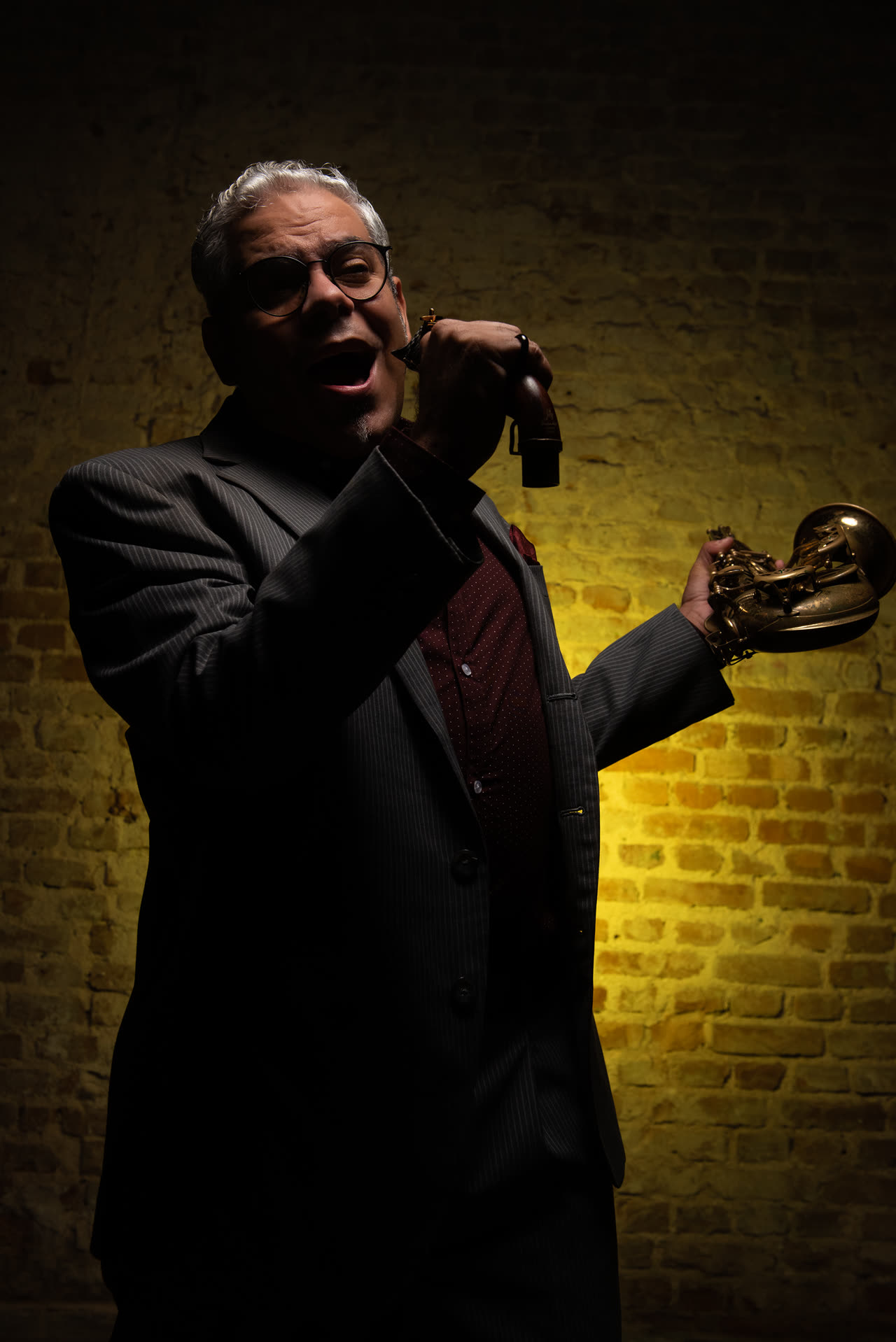 Retrato de un músico con trompeta bajo luz cálida lateral